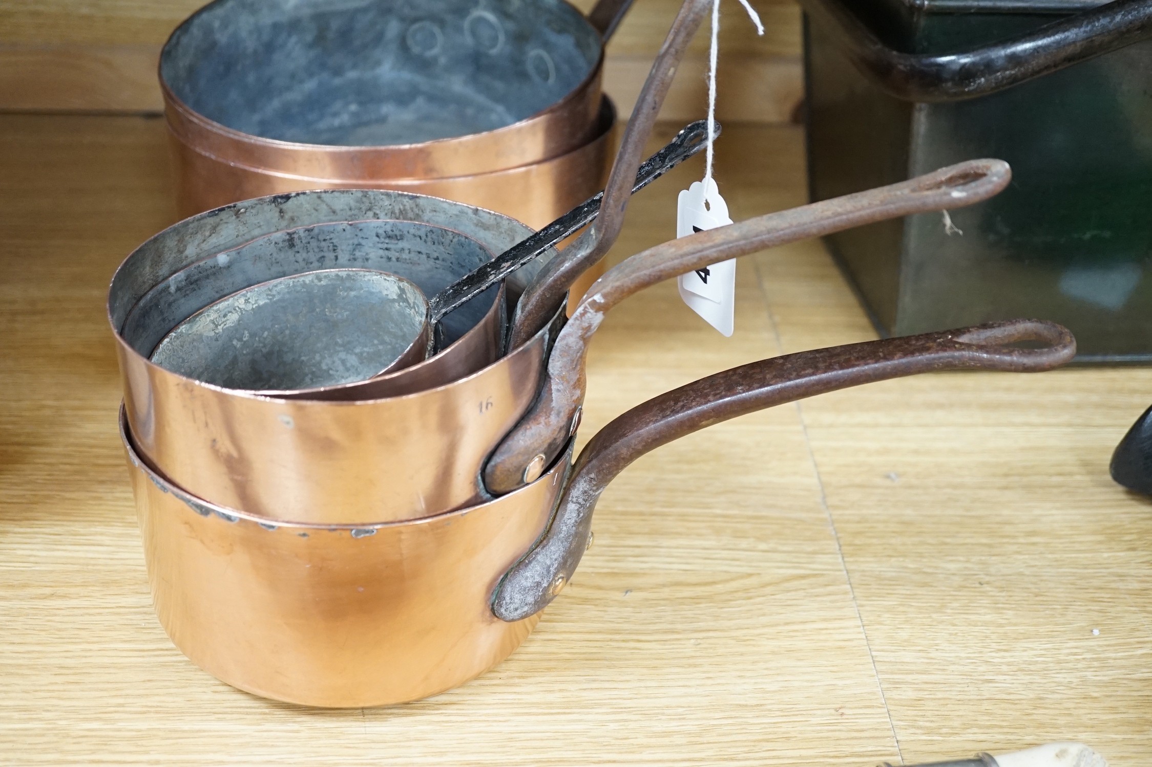 Seven graduated copper saucepans